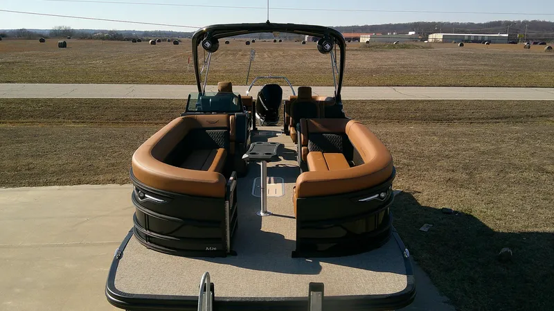 Slide: The Image of 2025 Bennington MFB 26 pontoon boat with brown seating, parked on a concrete surface. - 3