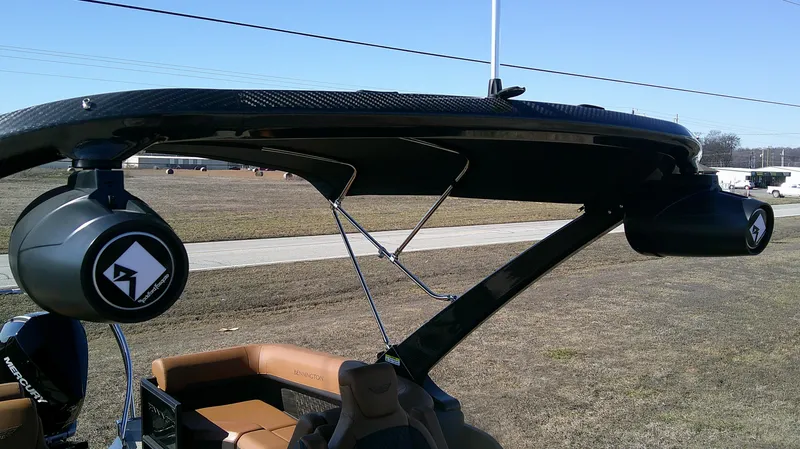 Slide: The Image of 2025 Bennington MFB 26 boat with speakers and canopy, parked on grassy area. - 6