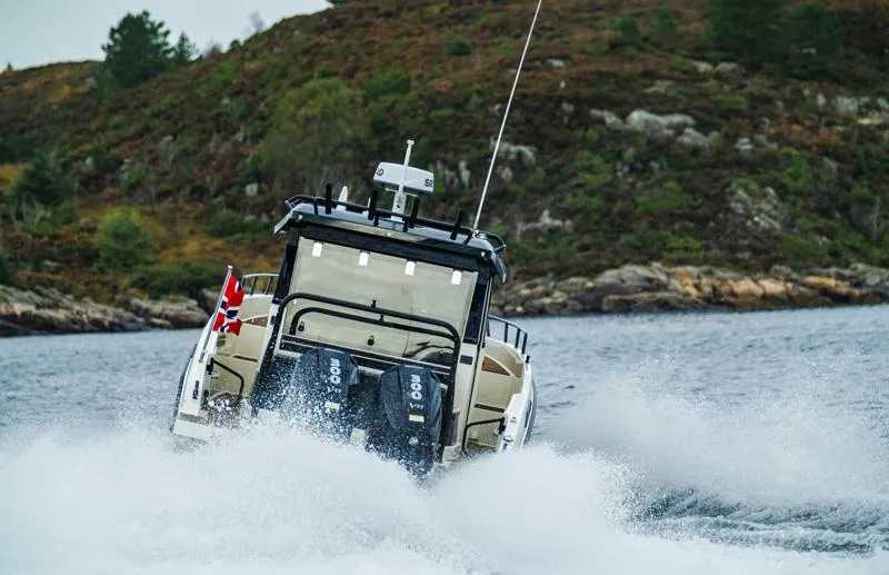 Slide: The Image of Navan C30 boat cruising on water, 2025 model, with scenic rocky shoreline backdrop. - 15