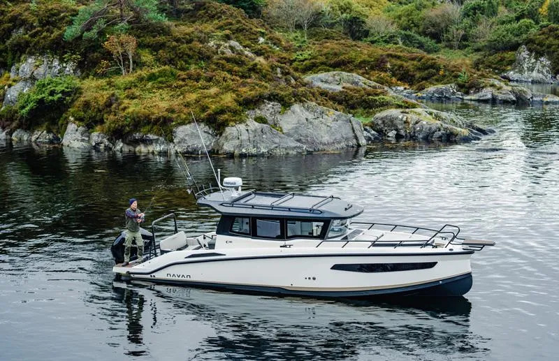 Slide: The Image of 2025 Navan C30 boat on scenic lake with rocky shoreline and lush greenery. - 25