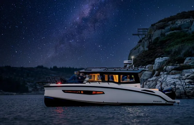 Slide: The Image of Navan C30 boat cruising under a starry night sky near rocky cliffs, 2025 model. - 6
