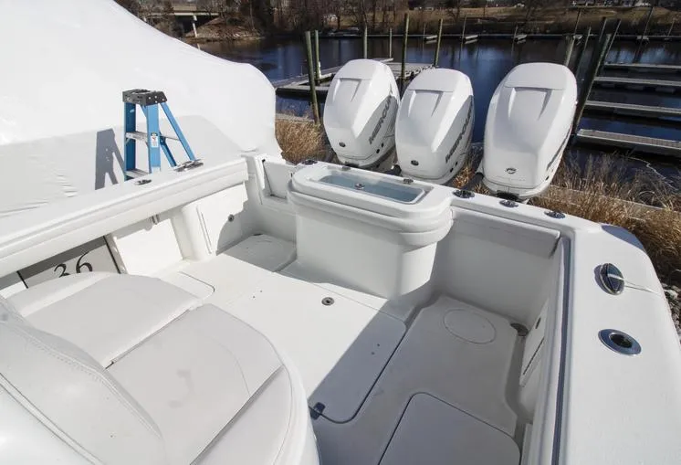 Slide: The Image of 2018 Yellowfin 36 boat interior with triple outboard engines, docked near a marina. - 16