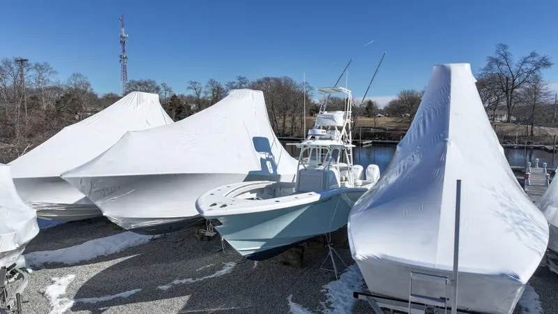 Slide: The Image of 2018 Yellowfin 36 boat stored outdoors, partially covered, surrounded by other wrapped boats. - 2
