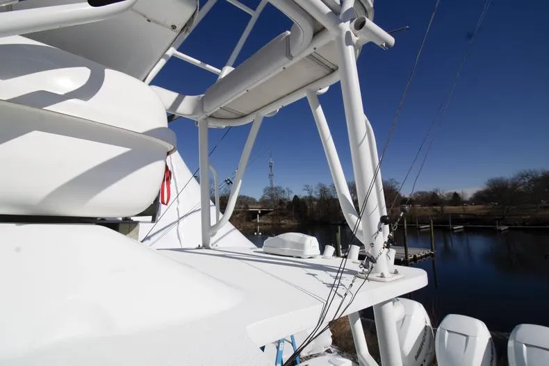 Slide: The Image of 2018 Yellowfin 36 boat with tower, docked by a serene waterfront under clear blue skies. - 8