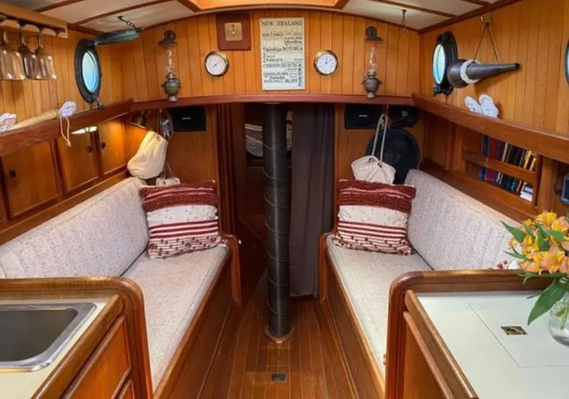 Slide: The Image of Interior of 1982 Bristol Channel Cutter 28, featuring cozy wood paneling and nautical decor. - 8