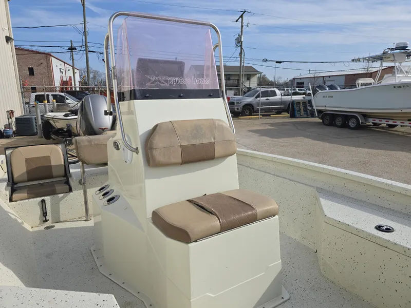Slide: The Image of 2019 Xpress H20B boat with beige seating and console, parked in a marina. - 7
