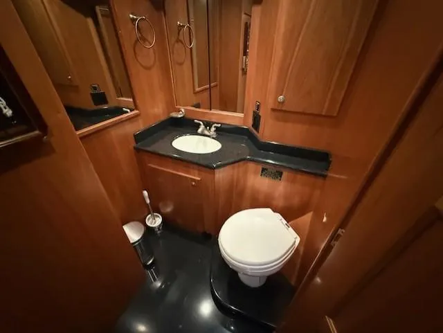 Slide: The Image of Luxurious 2007 Navigator 51 yacht bathroom with wood cabinetry and black countertop. - 19