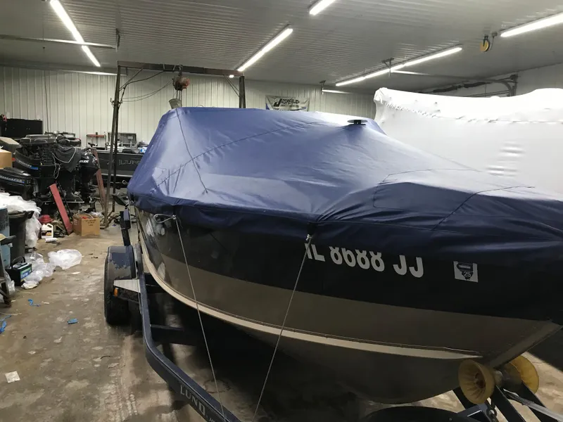 Slide: The Image of 1999 Lund 1800 Fisherman boat covered in a garage, ready for storage or transport. - 20