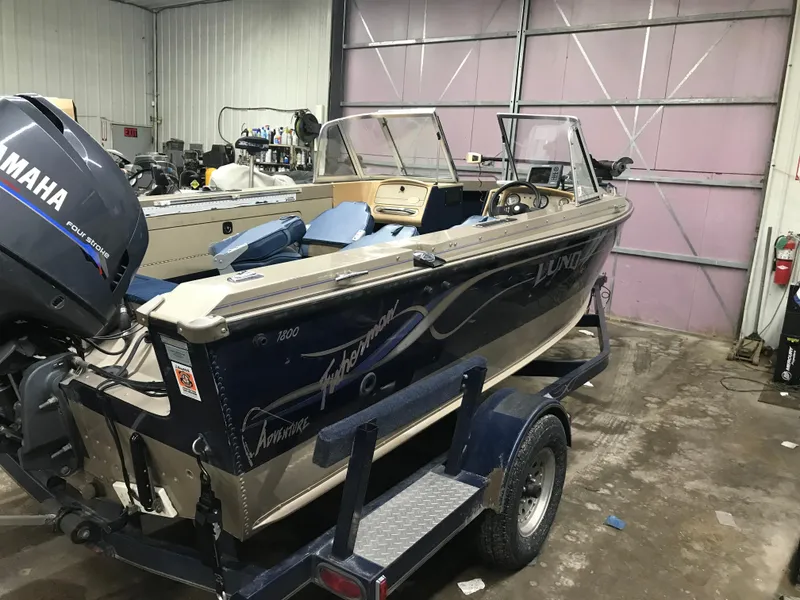 Slide: The Image of 1999 Lund 1800 Fisherman boat with Yamaha motor in a garage setting. - 3
