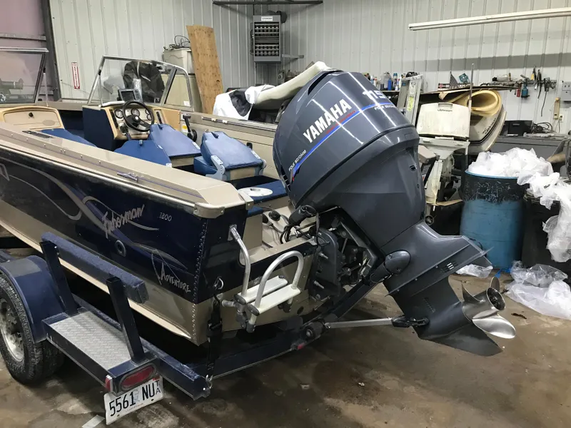 Slide: The Image of 1999 Lund 1800 Fisherman boat with Yamaha outboard motor in a workshop setting. - 5