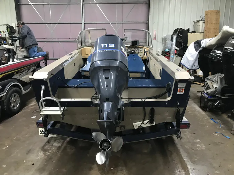 Slide: The Image of 1999 Lund 1800 Fisherman boat with 115 horsepower motor in a garage setting. - 6