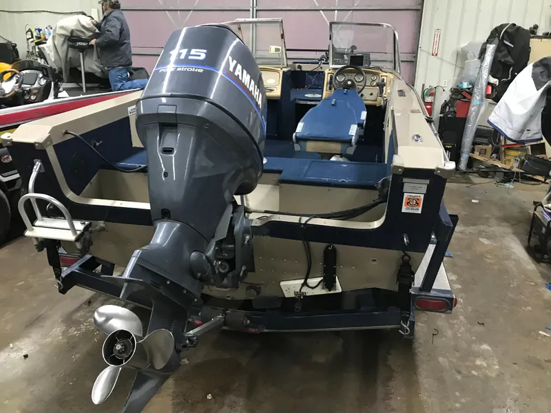 Slide: The Image of 1999 Lund 1800 Fisherman boat with Yamaha 115 outboard motor in a garage. - 7