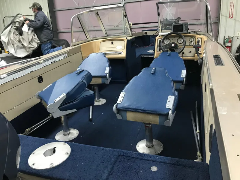 Slide: The Image of 1999 Lund 1800 Fisherman boat interior with blue seats and steering wheel. - 8