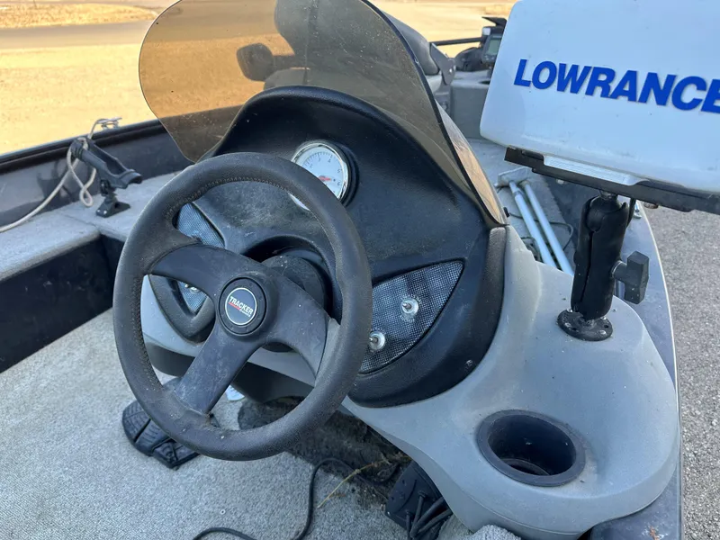 Slide: The Image of 2011 Tracker Super Guide V16 boat dashboard with steering wheel and Lowrance device. - 4