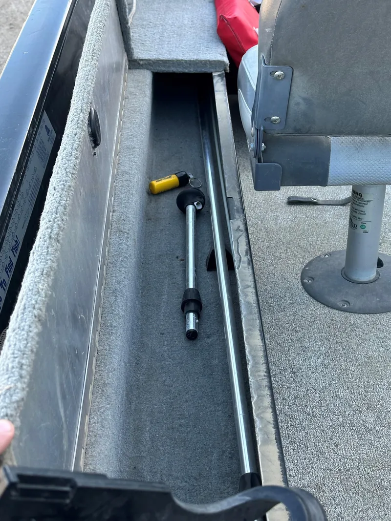 Slide: The Image of 2011 Tracker Super Guide V16 boat storage compartment with fishing rod holders. - 7