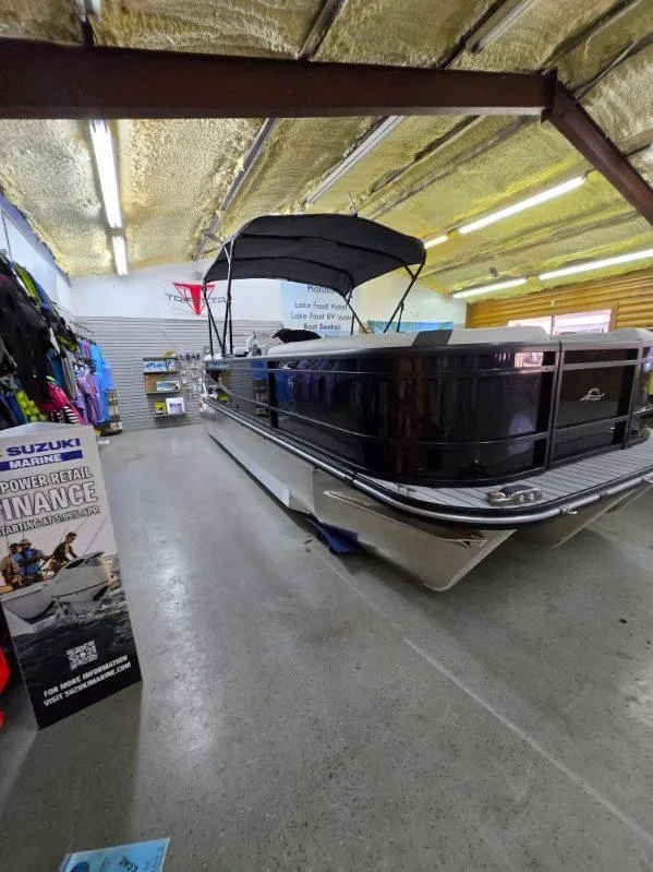Slide: The Image of 2025 G3 322rc boat displayed indoors with canopy, surrounded by boating accessories. - 2