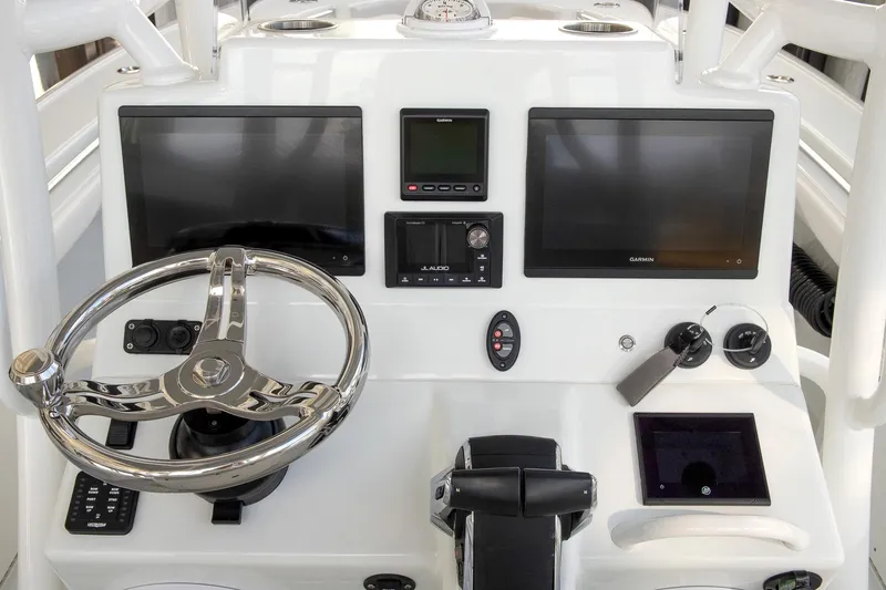Slide: The Image of 2023 Yellowfin 26 Hybrid boat dashboard with dual screens and steering wheel. - 16