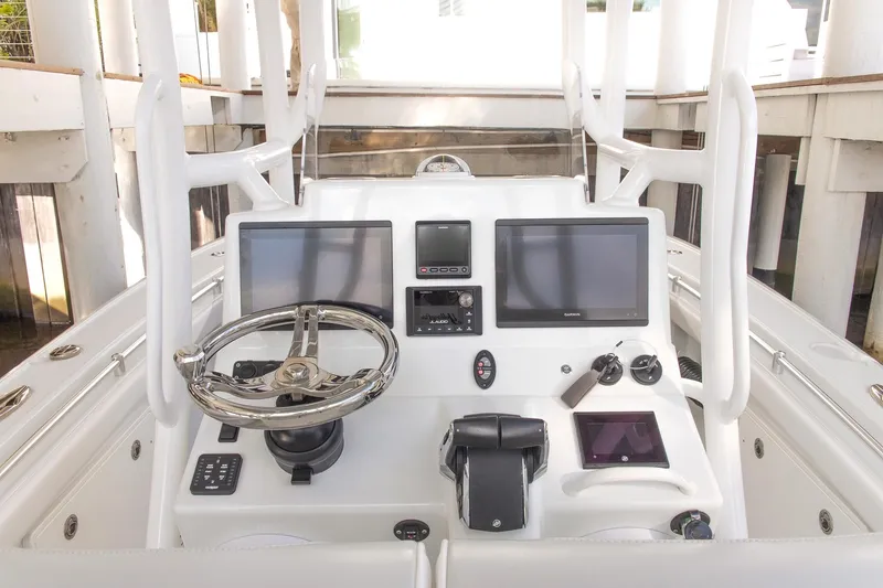 Slide: The Image of 2023 Yellowfin 26 Hybrid boat dashboard with dual screens and steering wheel. - 17