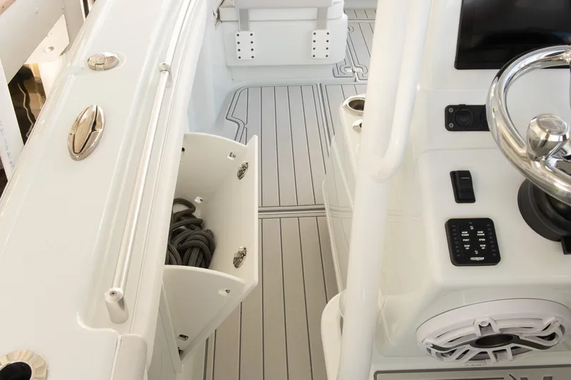 Slide: The Image of 2023 Yellowfin 26 Hybrid boat interior with storage compartment and steering wheel. - 20