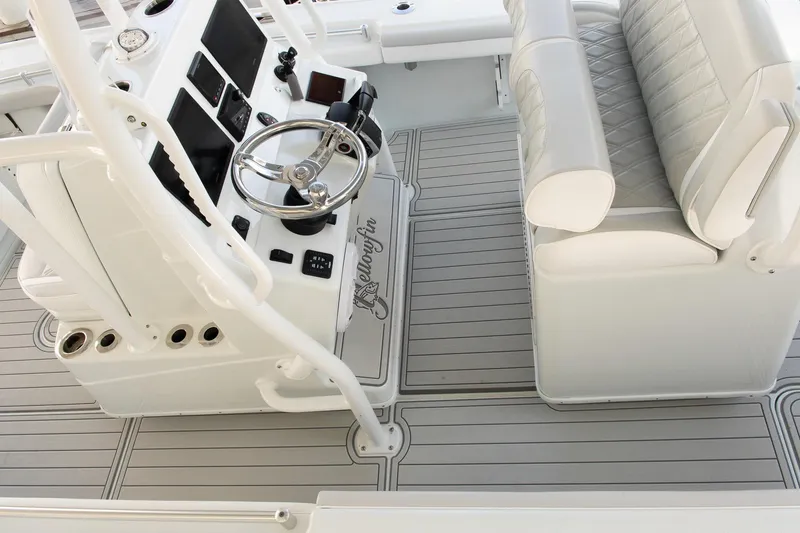 Slide: The Image of 2023 Yellowfin 26 Hybrid boat interior with steering wheel and cushioned seating. - 24