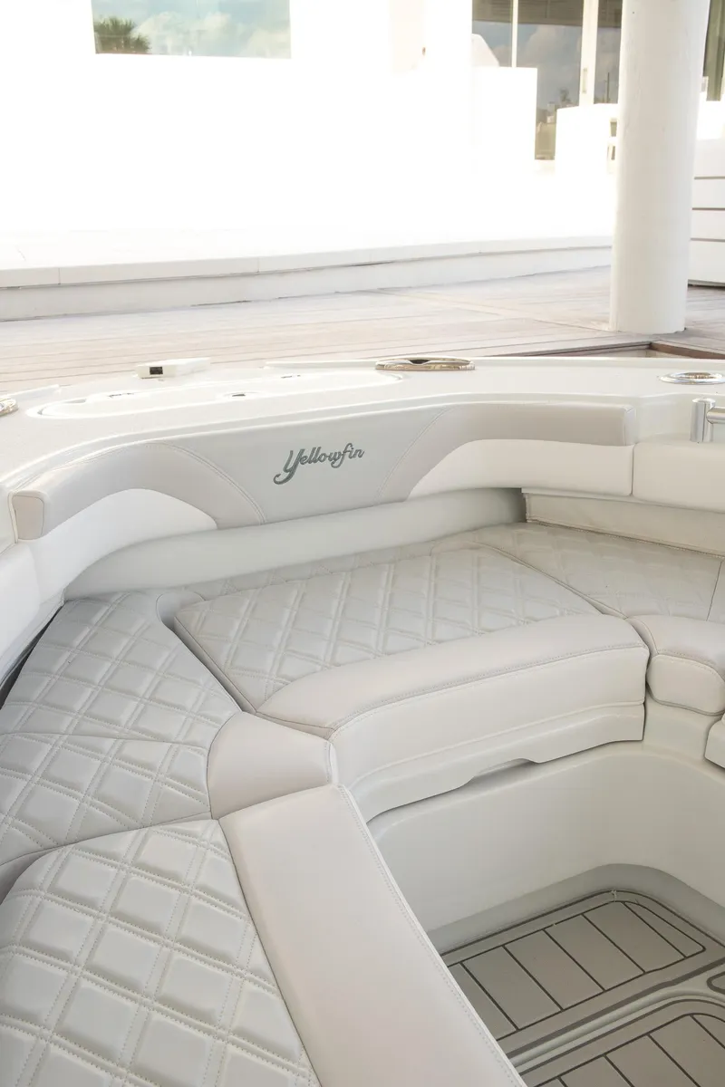Slide: The Image of 2023 Yellowfin 26 Hybrid boat interior with white cushioned seating. - 26