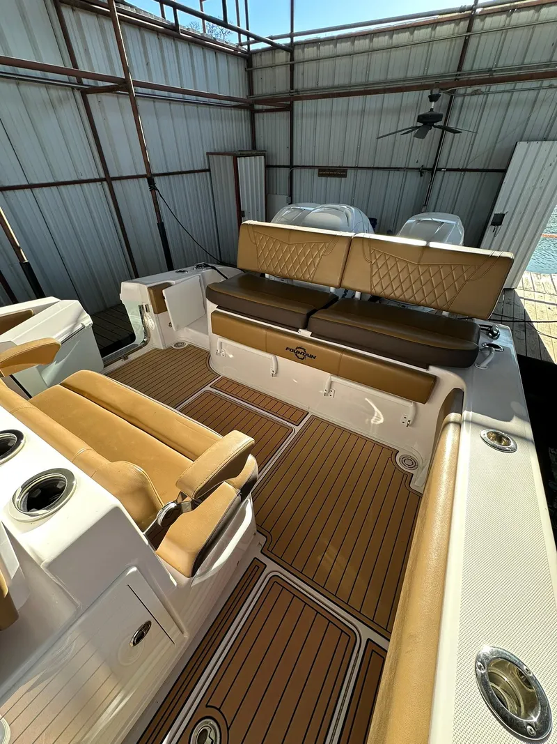 Slide: The Image of 2018 Fountain 38 CC boat interior with tan seating and wood-style flooring. - 13