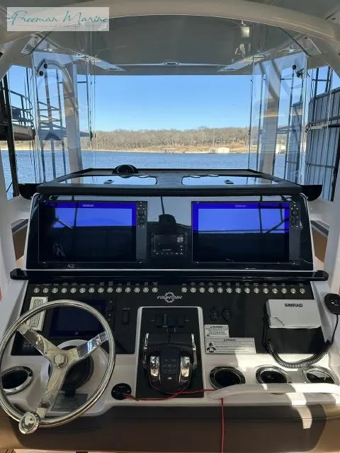 Slide: The Image of 2018 Fountain 38 CC boat dashboard with navigation screens and steering wheel. - 14