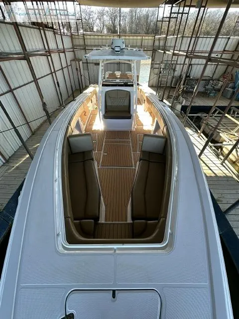 Slide: The Image of 2018 Fountain 38 CC boat with spacious deck and seating in a covered dock. - 16