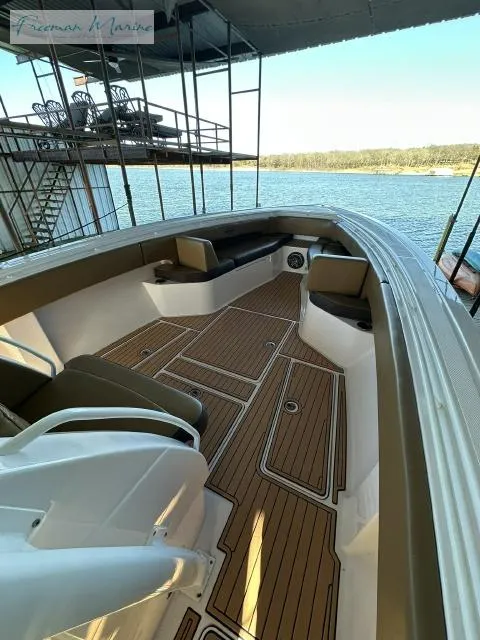 Slide: The Image of 2018 Fountain 38 CC boat with spacious deck and seating, docked by a serene lake. - 18