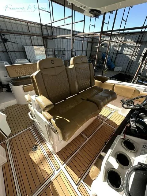 Slide: The Image of 2018 Fountain 38 CC boat interior with tan leather seats and wood-patterned flooring. - 19
