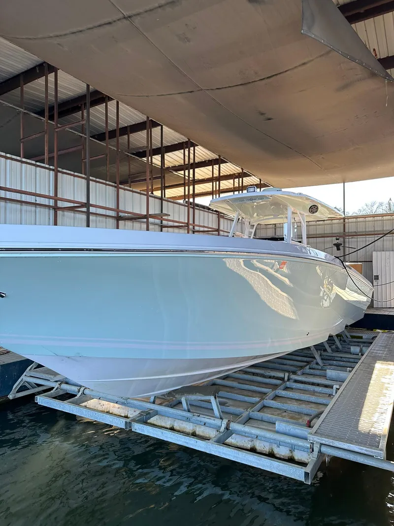 Slide: The Image of 2018 Fountain 38 CC boat in dry dock, side view, under a metal roof. - 2