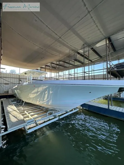 Slide: The Image of 2018 Fountain 38 CC boat in dock, side view under covered marina. - 23