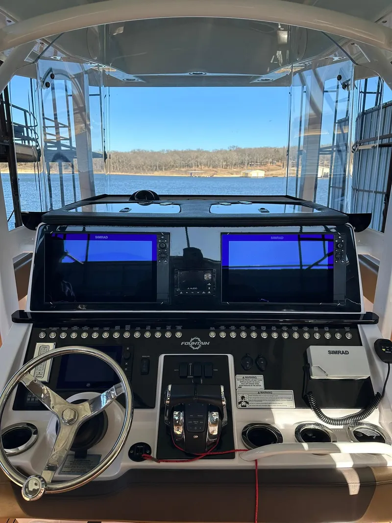 Slide: The Image of 2018 Fountain 38 CC boat dashboard with dual screens and steering wheel. - 6