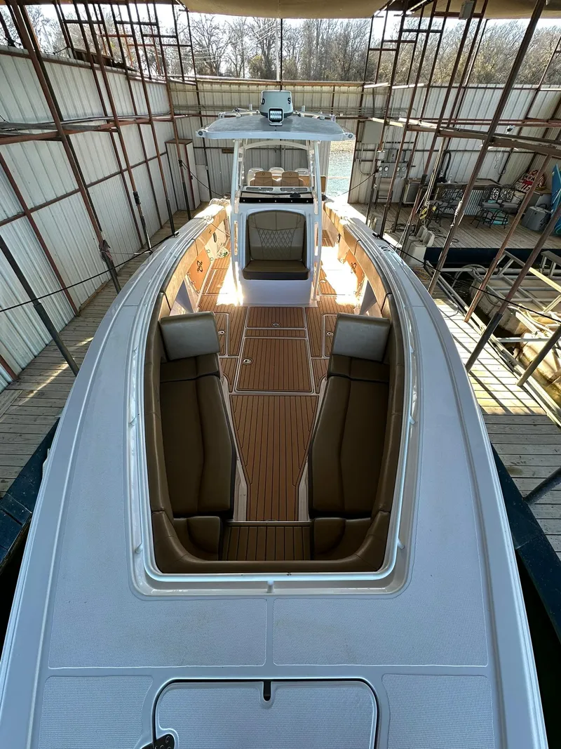 Slide: The Image of 2018 Fountain 38 CC boat with sleek design and spacious deck in a covered dock. - 8