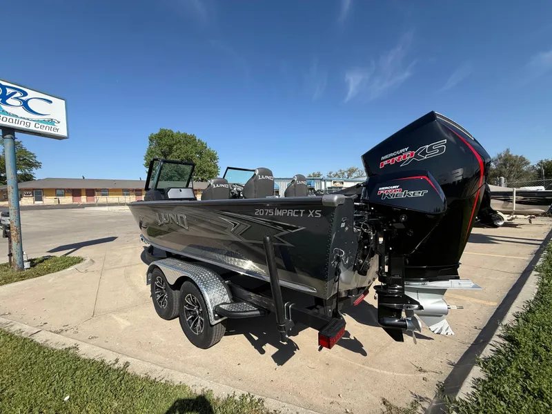 Slide: The Image of 2025 Lund 2075 IMPACT XS boat with powerful outboard motor in a parking lot. - 3