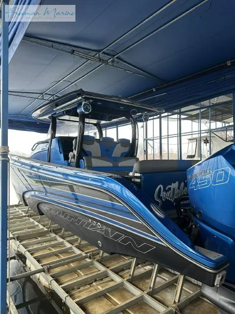 Slide: The Image of 2023 Fountain 43 NX boat in blue, docked under a canopy. - 1