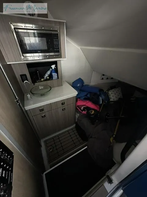 Slide: The Image of 2023 Fountain 43 NX cabin interior with kitchenette and storage area. - 13