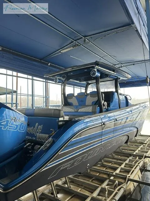 Slide: The Image of 2023 Fountain 43 NX boat in blue, docked under a canopy. - 3