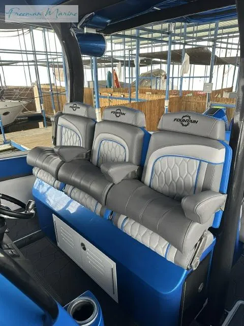 Slide: The Image of 2023 Fountain 43 NX boat interior with luxurious seating in a marina setting. - 6