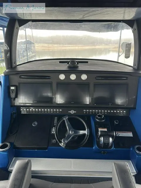 Slide: The Image of 2023 Fountain 43 NX boat dashboard with steering wheel and control panels. - 7