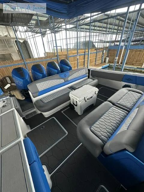Slide: The Image of 2023 Fountain 43 NX boat interior with blue and gray seating, cooler, and multiple outboard engines. - 9