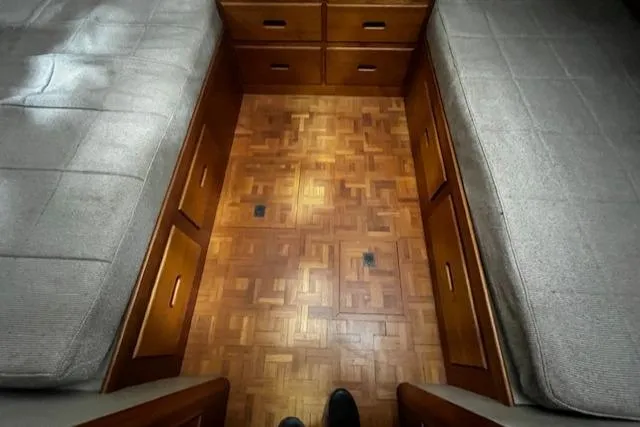 Slide: The Image of 1984 Grand Banks Trawler cabin interior with parquet flooring and twin beds. - 14