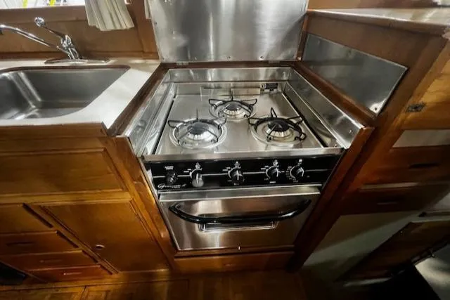 Slide: The Image of 1984 Grand Banks Trawler kitchen with stainless steel stove and sink. - 15