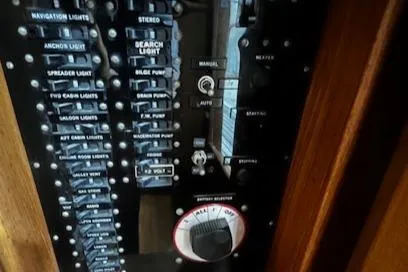 Slide: The Image of Control panel of a 1984 Grand Banks Trawler with various switches and dials. - 19