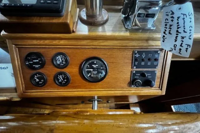 Slide: The Image of 1984 Grand Banks Trawler dashboard with gauges and controls in wooden panel. - 22
