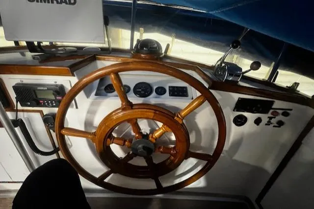 Slide: The Image of 1984 Grand Banks Trawler helm with wooden steering wheel and navigation instruments. - 23