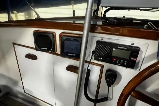 Slide: The Image of 1984 Grand Banks Trawler helm with Simrad electronics and classic wood trim. - 24