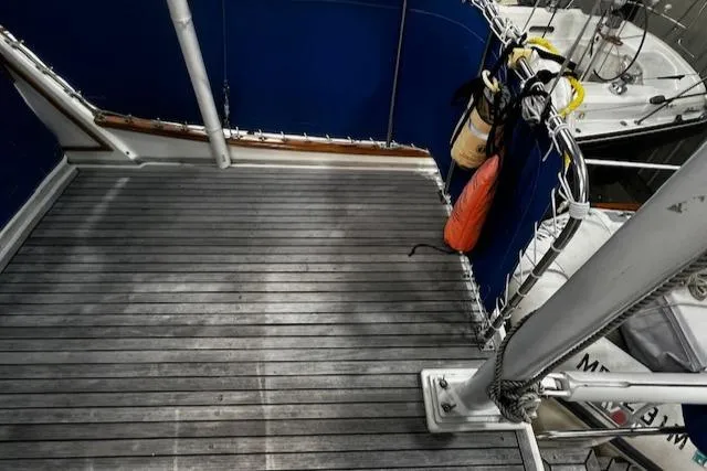 Slide: The Image of 1984 Grand Banks Trawler deck with blue railing and safety equipment. - 26