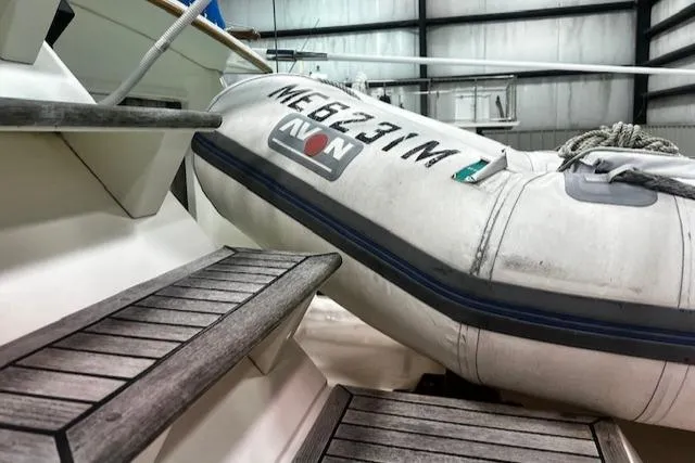 Slide: The Image of 1984 Grand Banks Trawler with Avon dinghy on deck, wooden steps visible. - 34