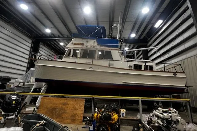 Slide: The Image of 1984 Grand Banks Trawler in a warehouse, showcasing classic design and sturdy construction. - 37